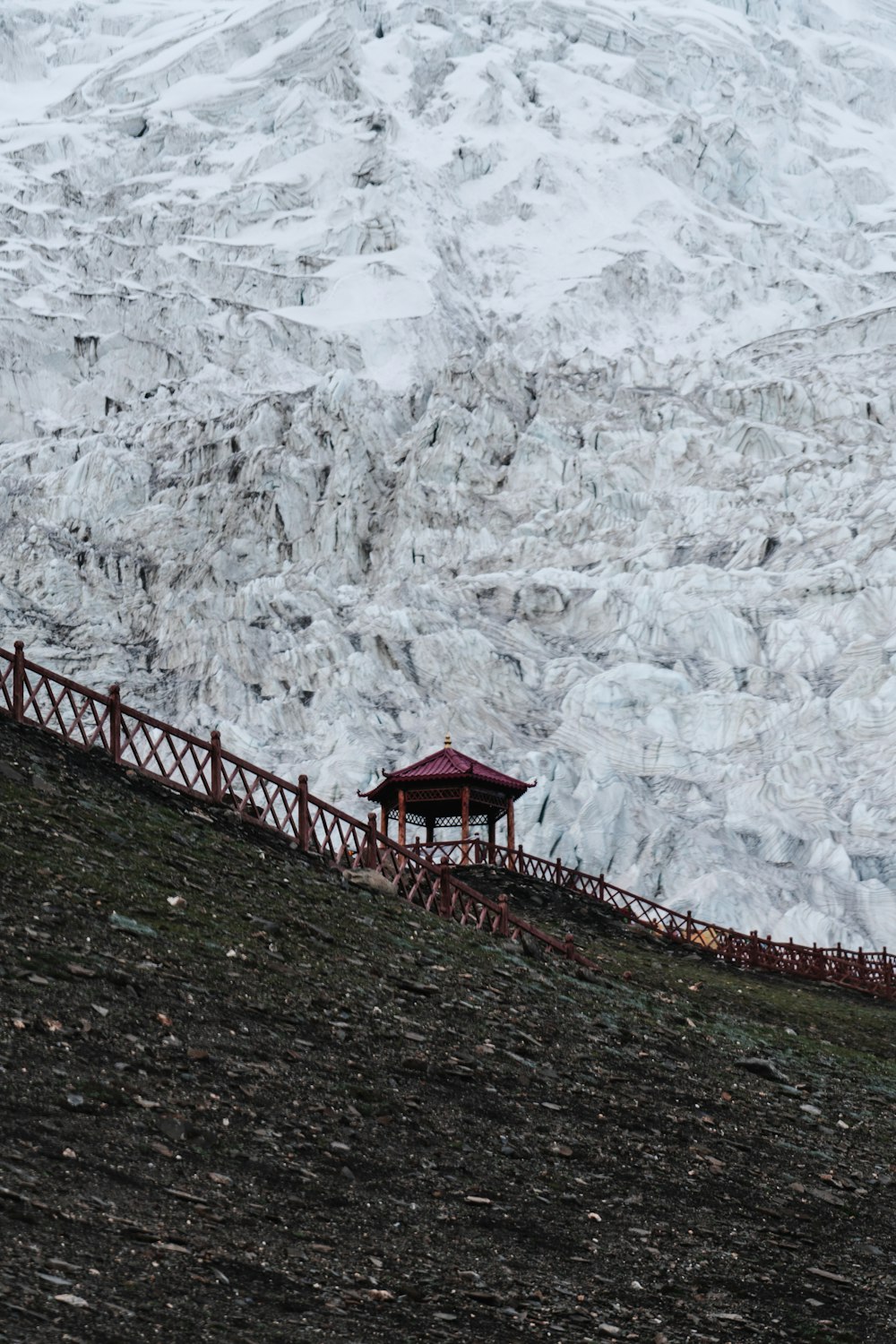 brown wooden bridge on mountain covered with snow