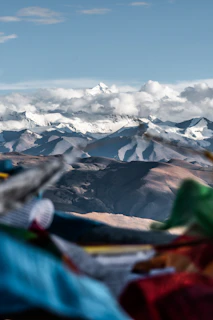 Floating card featuring the snow-capped peaks of Himachal Pradesh under a clear blue sky.