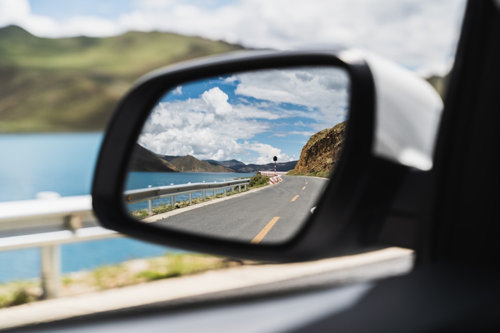 car side mirror showing city buildings during daytime