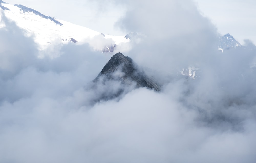 white clouds over snow covered mountain