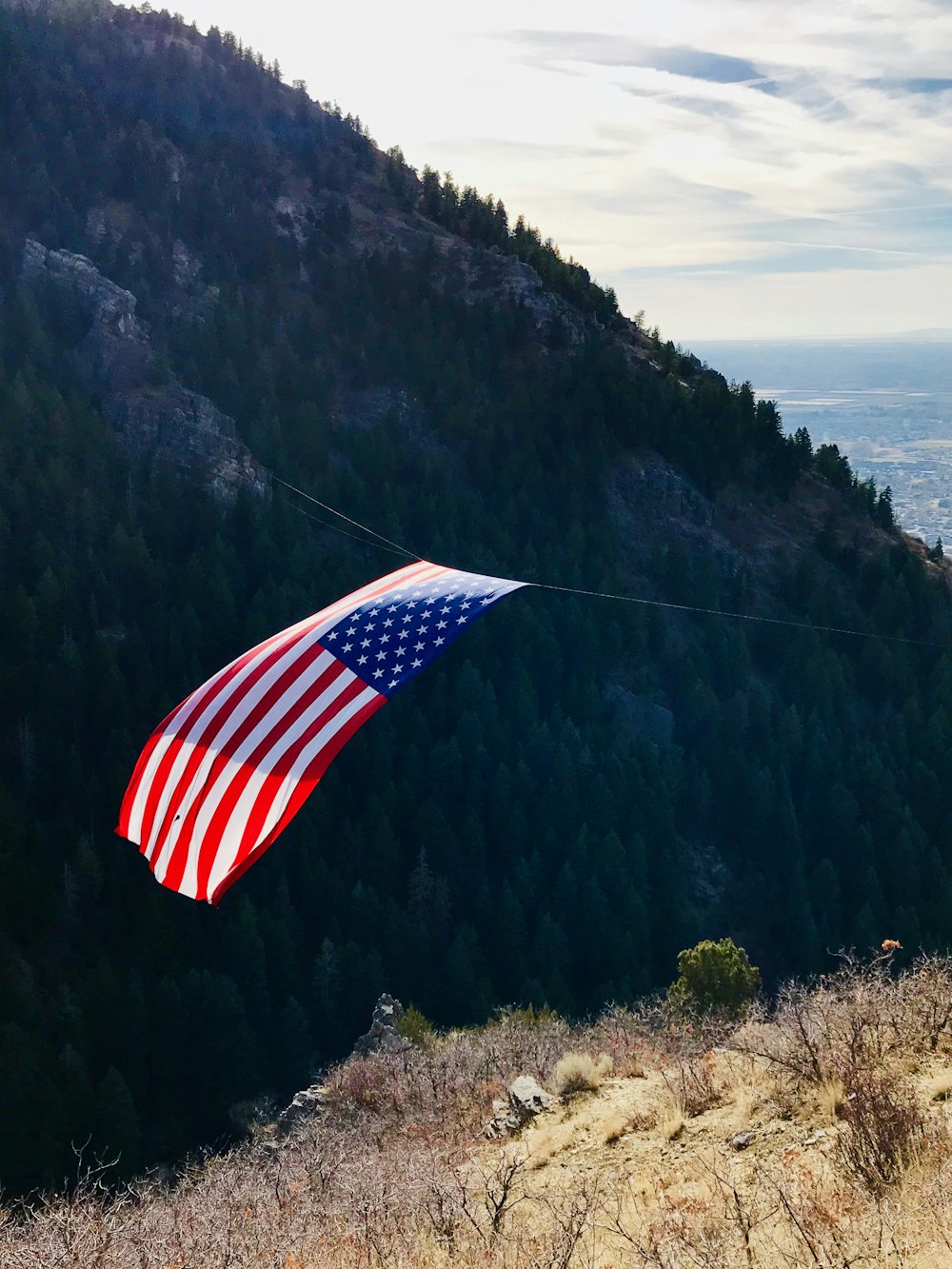 us a flag on top of mountain during daytime