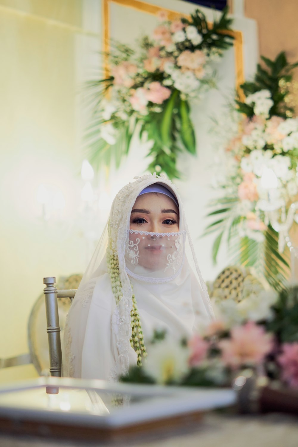 woman in white hijab standing near green plant