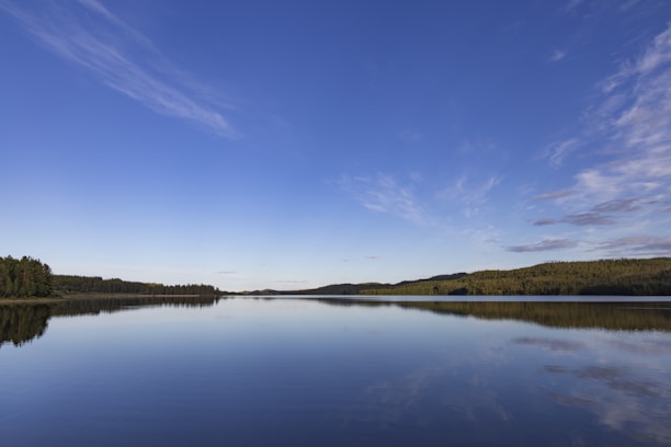 A serene landscape with a calm lake reflecting the sky, symbolizing peace and mental well-being.