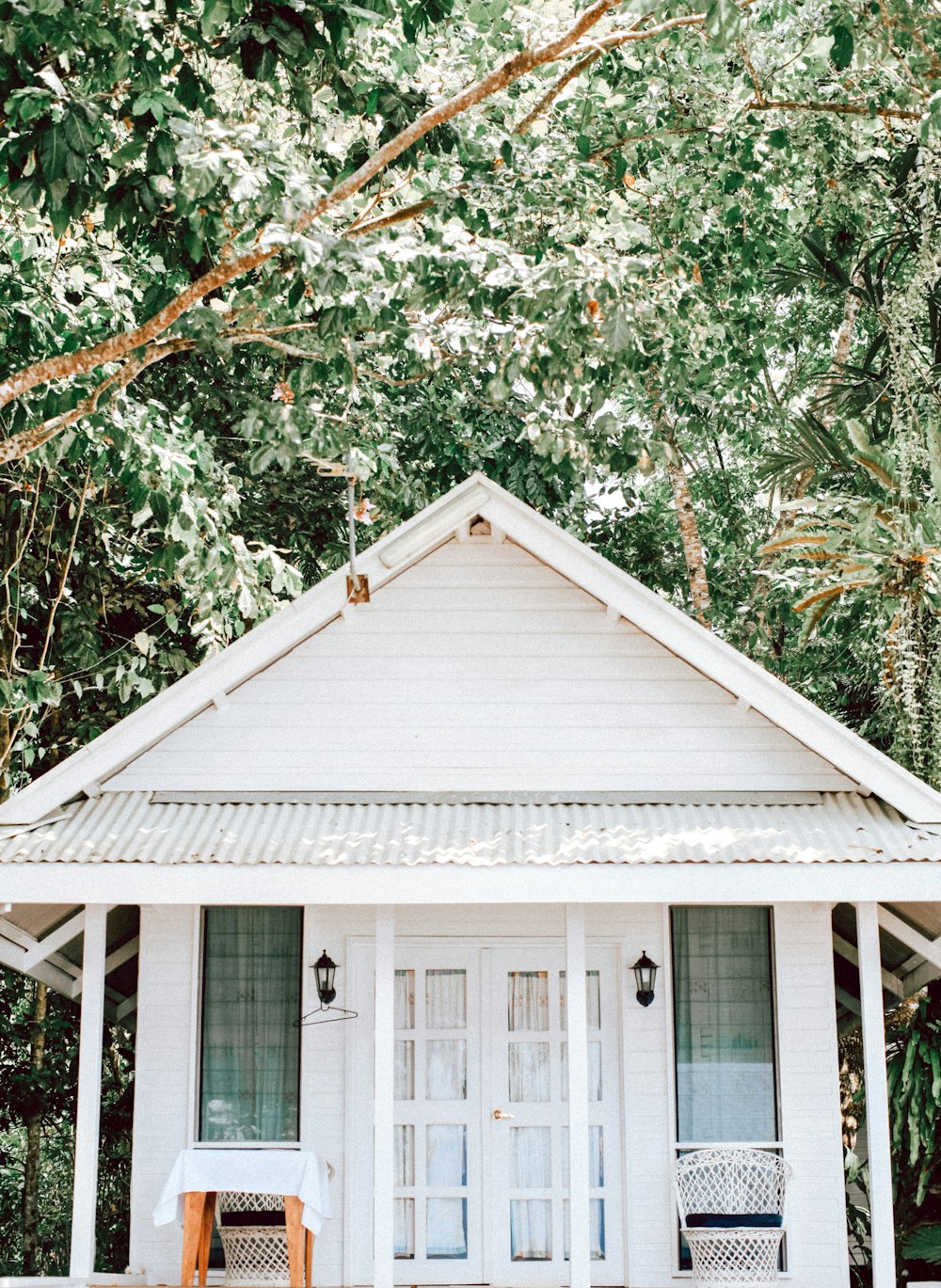 white wooden house surrounded by green trees during daytime