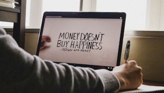 a person writing on a computer screen with a pen