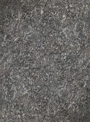 A close-up view of textured asphalt road surface with visible rough and bumpy aggregate particles. The image captures the gritty details and uneven nature of the asphalt material.