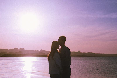Sunset silhouette of a couple embracing near iconic Melbourne cityscape.