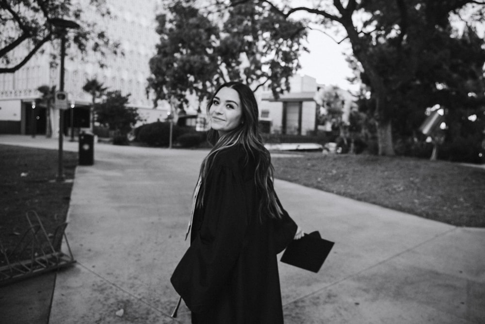 woman in black coat standing on the street