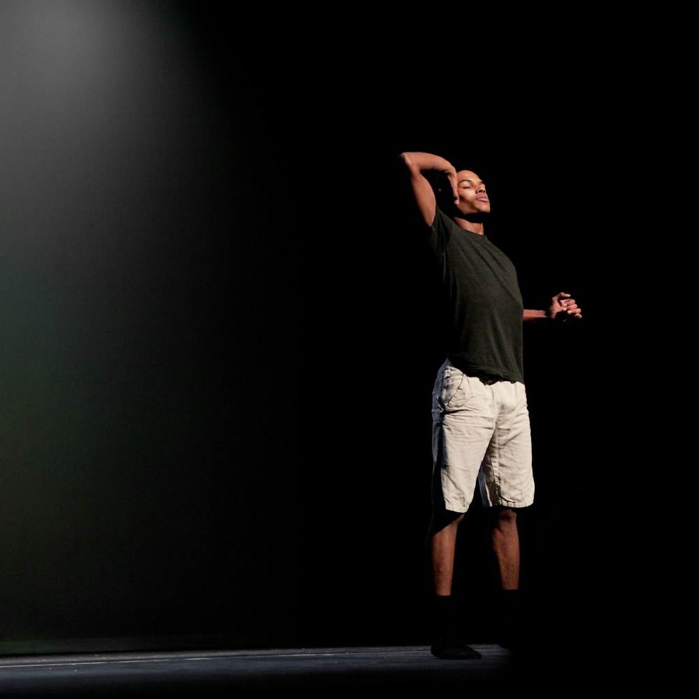 man in black t-shirt and white shorts standing