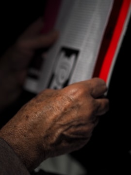 Close-up of a hand flipping through the pages of age care living's print guide.