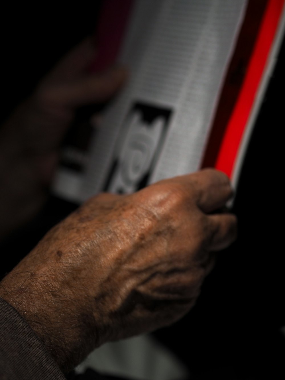 person holding white and red textile