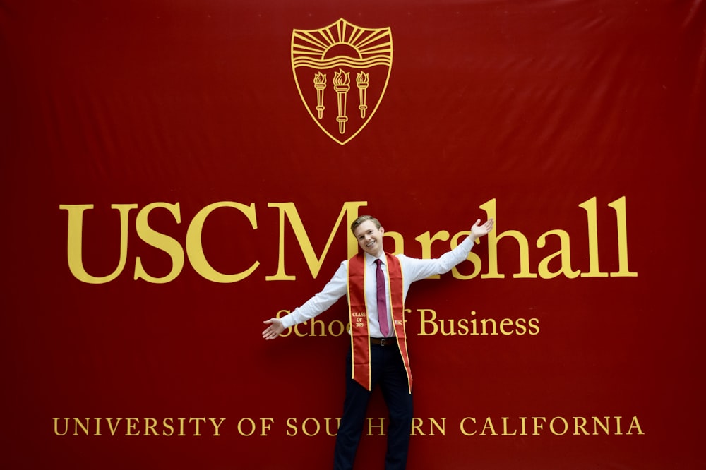 woman in white long sleeve shirt and black pants standing on red background