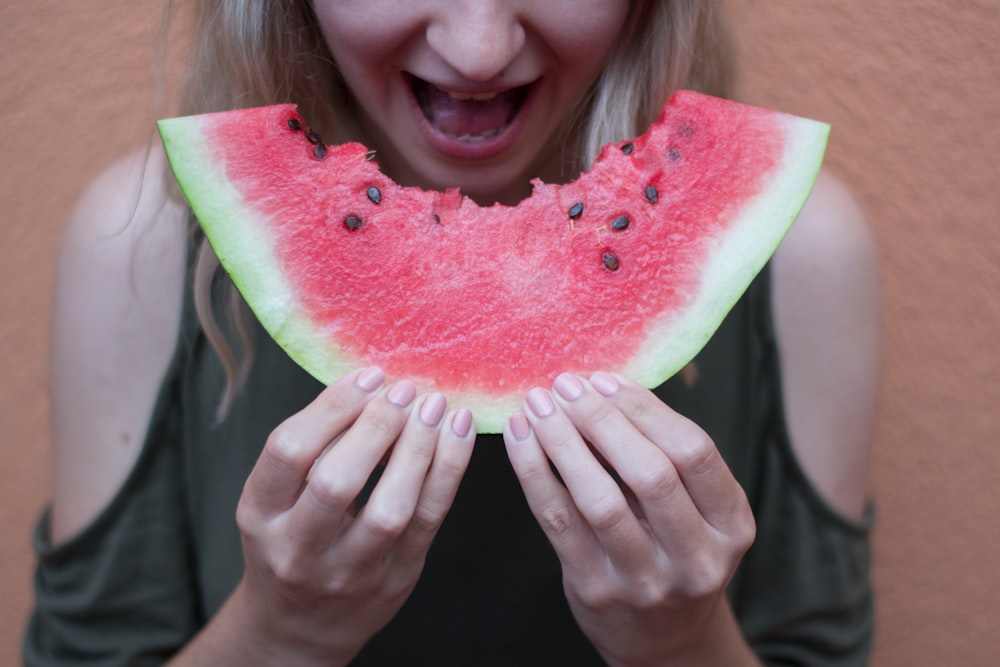 woman holding watermelon with tongue out