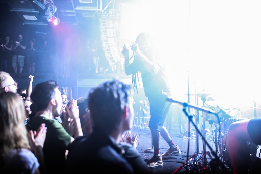 man in black shirt singing on stage