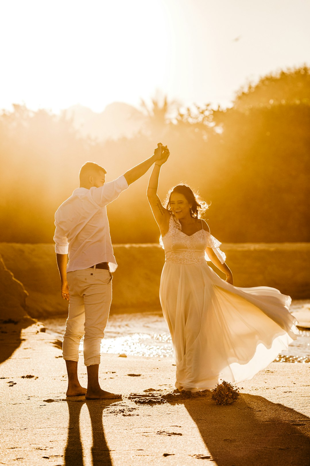 man and woman kissing on beach during sunset