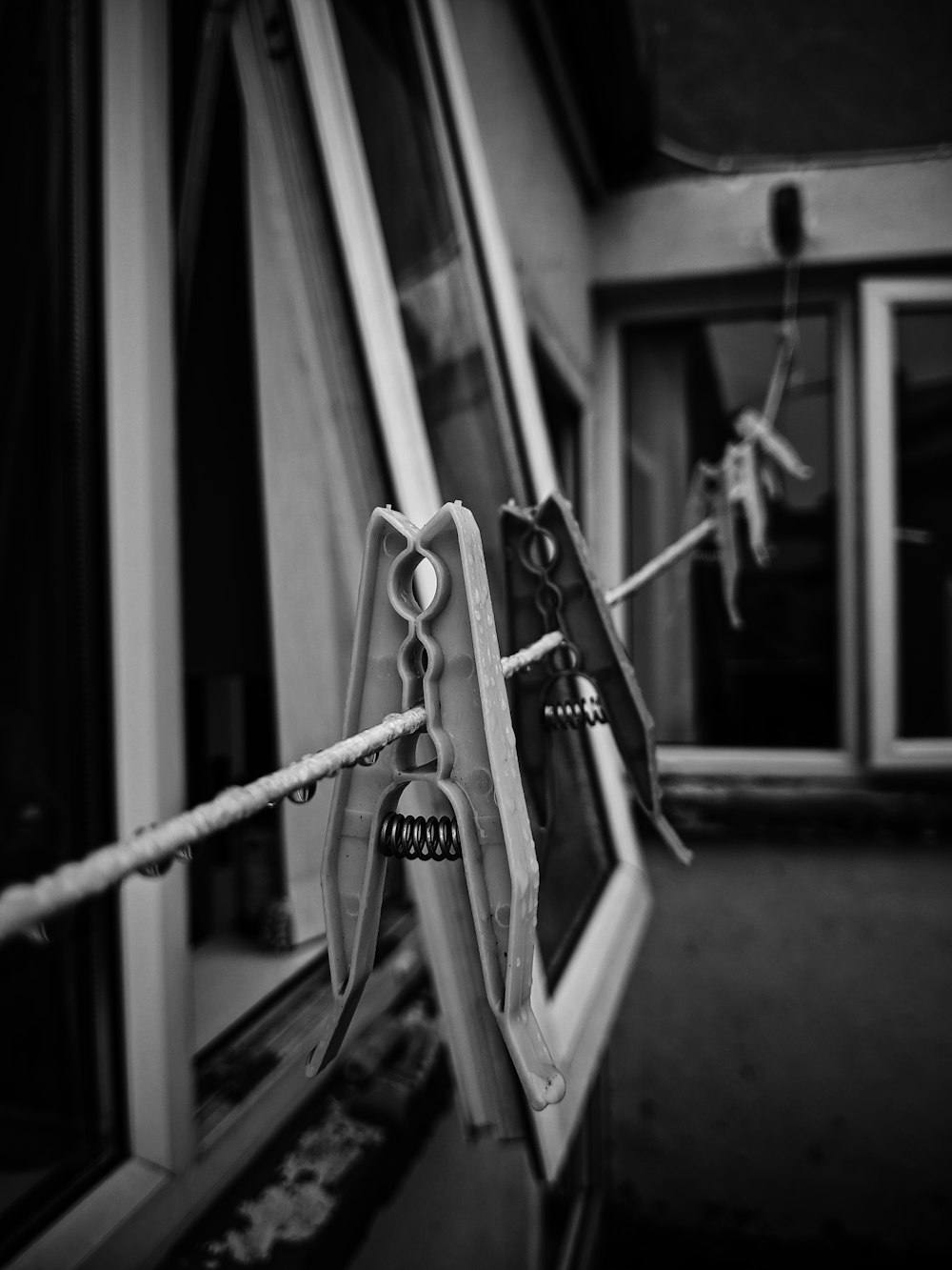 grayscale photo of bicycle in front of window