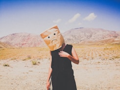 woman in black dress holding brown paper bag