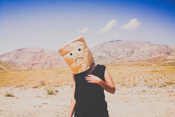 woman in black dress holding brown paper bag