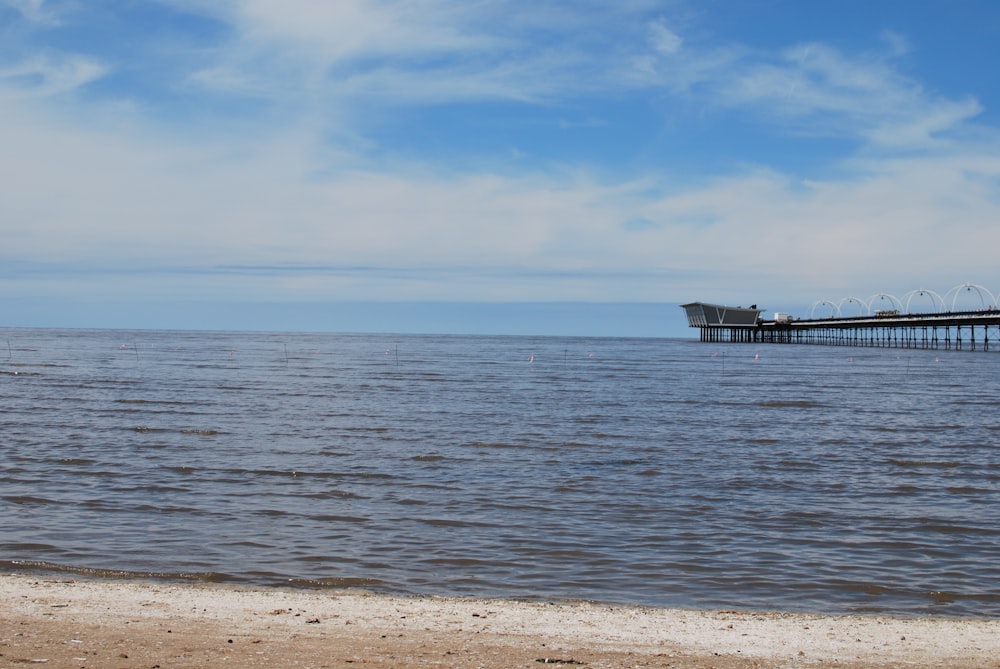 brown wooden dock on sea under blue sky during daytime