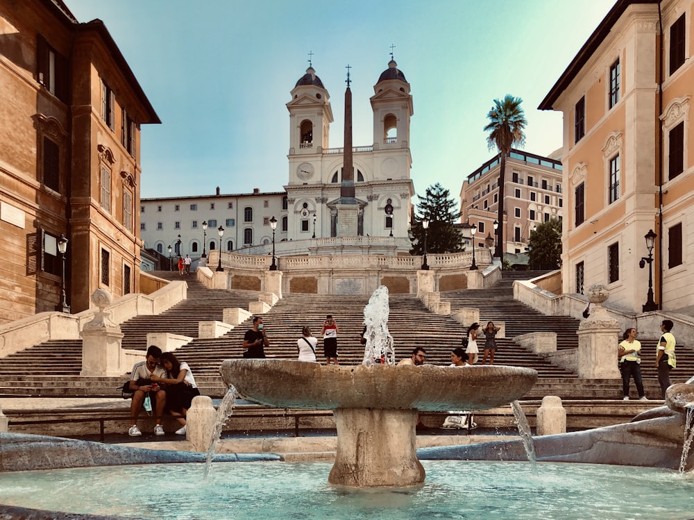 fountain in front of white concrete building during daytime