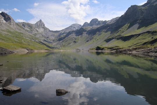 green mountains beside lake during daytime in Glattalpsee Switzerland