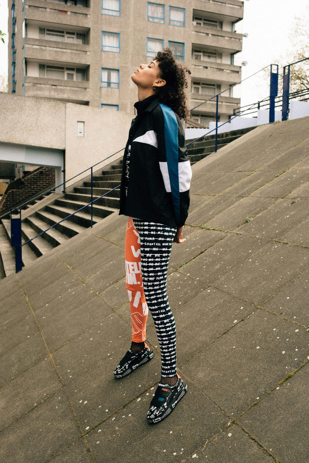 Femme en uniforme scolaire noir et blanc debout sur un sol en béton gris pendant la journée