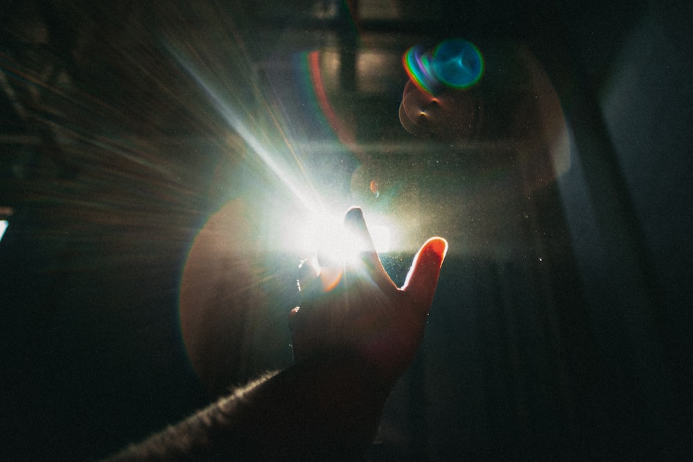 person holding light in dark room