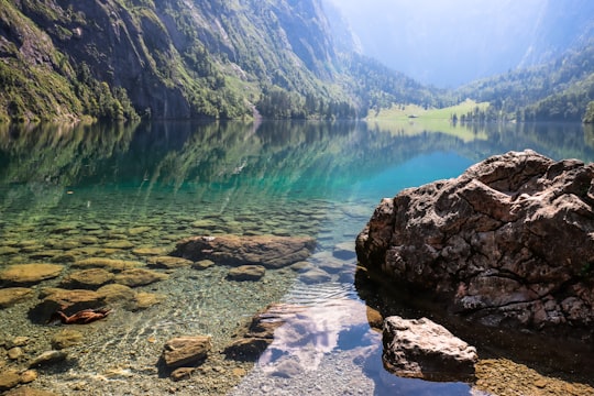 green lake surrounded by mountains during daytime in Berchtesgaden National Park Germany