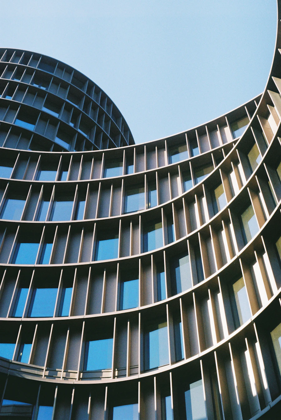 Curved facade of a tall building with bands of windows