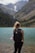 woman in black tank top carrying black backpack standing on seashore during daytime