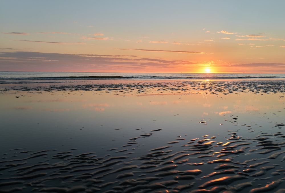 mare calmo sotto il cielo blu durante il tramonto