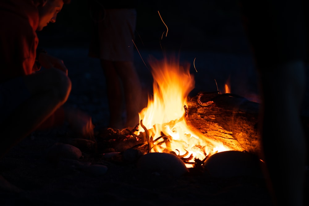 man in black jacket standing near bonfire