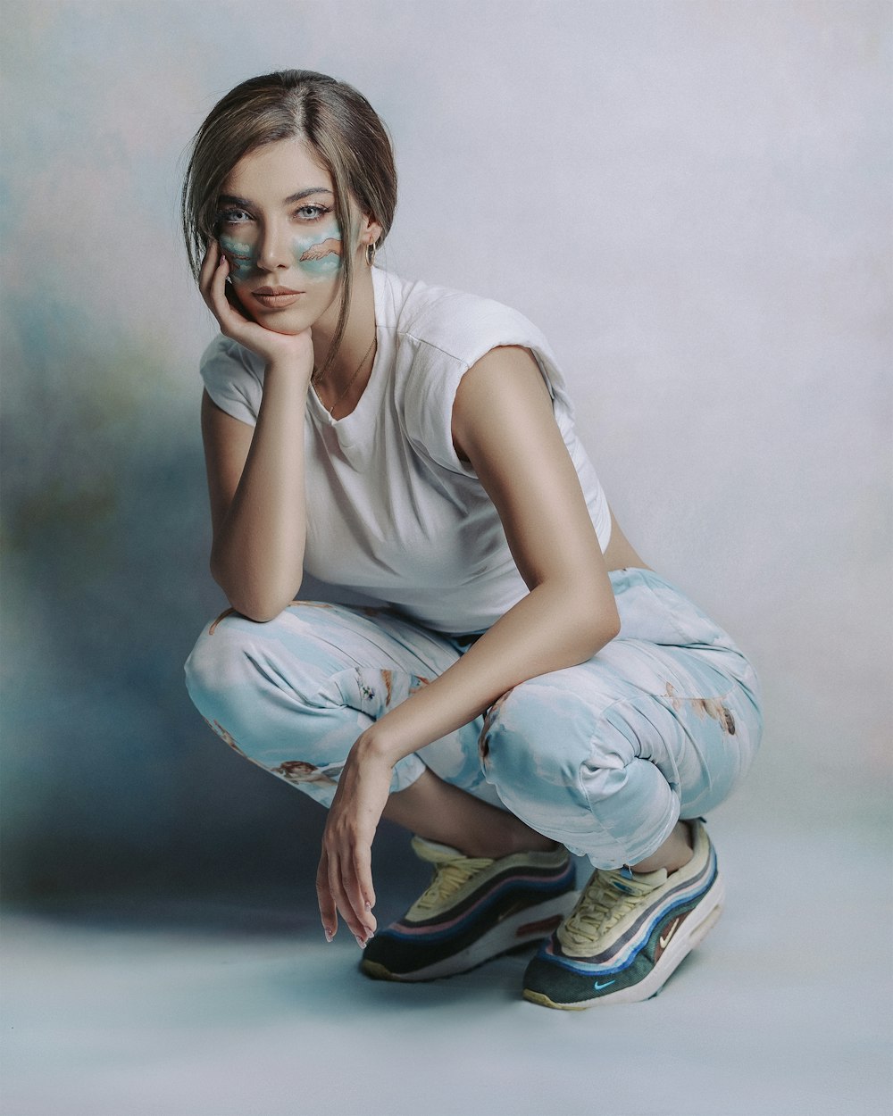 woman in white tank top and blue and white pants sitting on floor