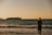 woman in black dress standing on seashore during sunset