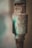 A close-up of an old, rusted metal pipe with visible inscriptions and patches of green and brown corrosion.