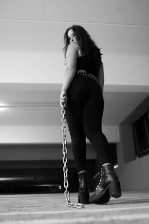 woman in black pants and black boots standing on stairs