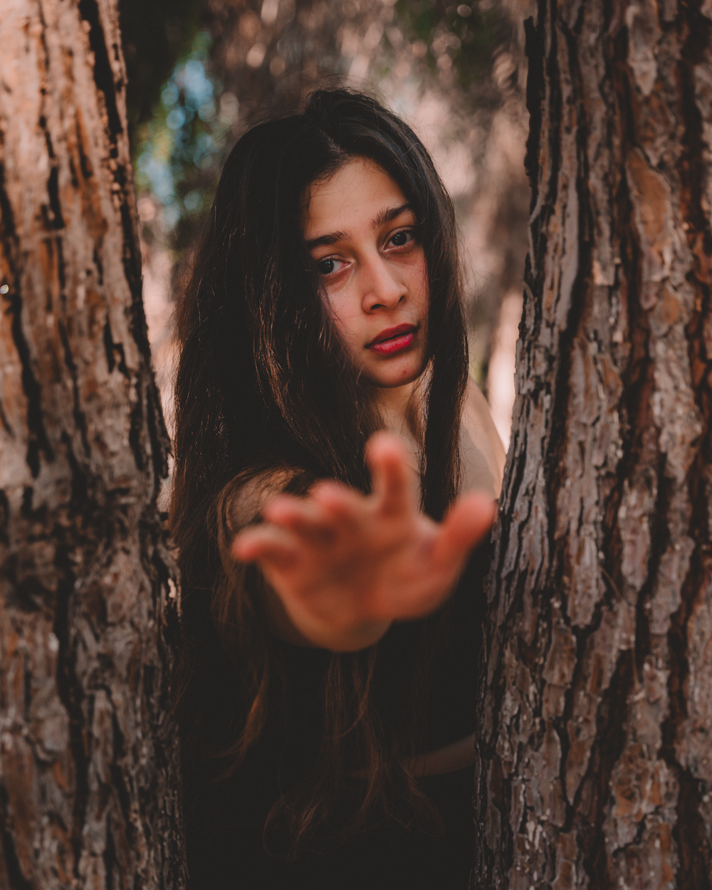 woman leaning on brown tree