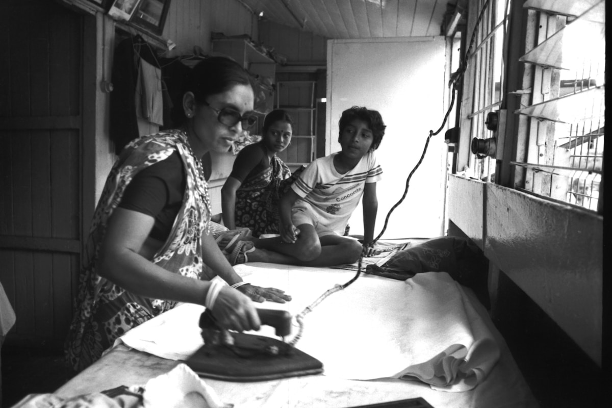 Grayscale image of a man and woman sitting on chairs, discussing volunteer appreciation ideas.