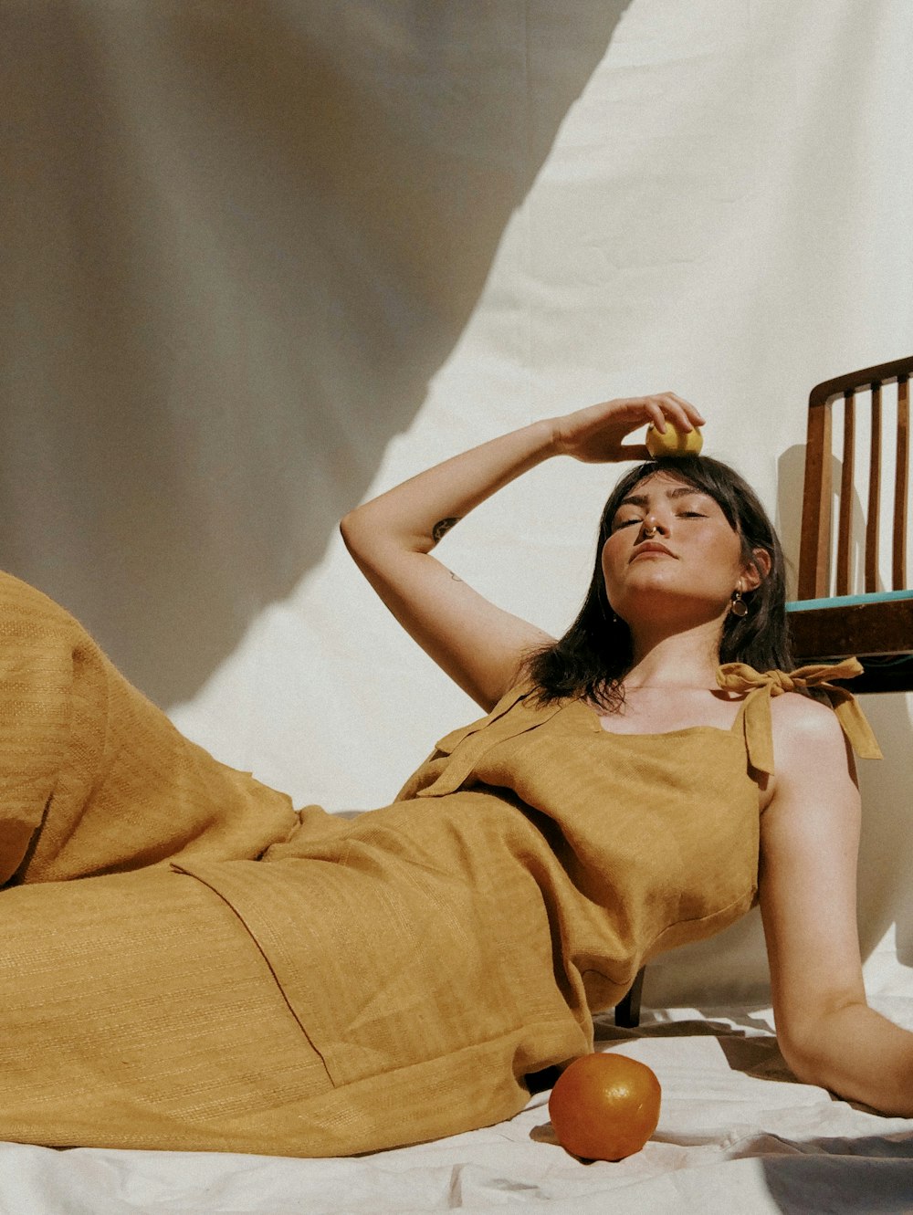 donna in abito senza maniche marrone sdraiata sul letto