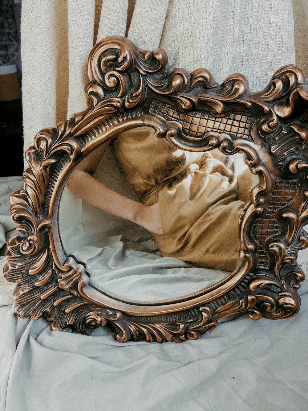 brown wooden framed mirror on white textile