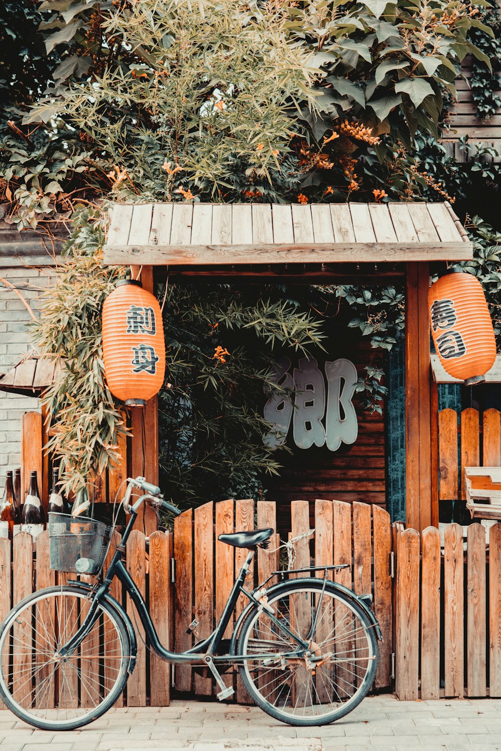 Bicicleta urbana negra junto a la pared de madera marrón