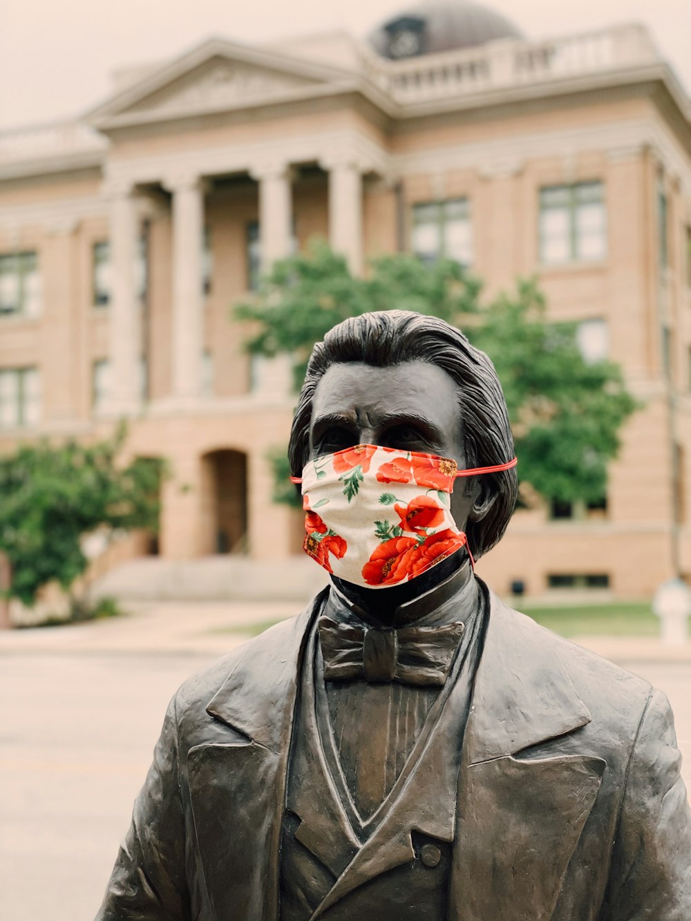 person in grey leather jacket with red face mask