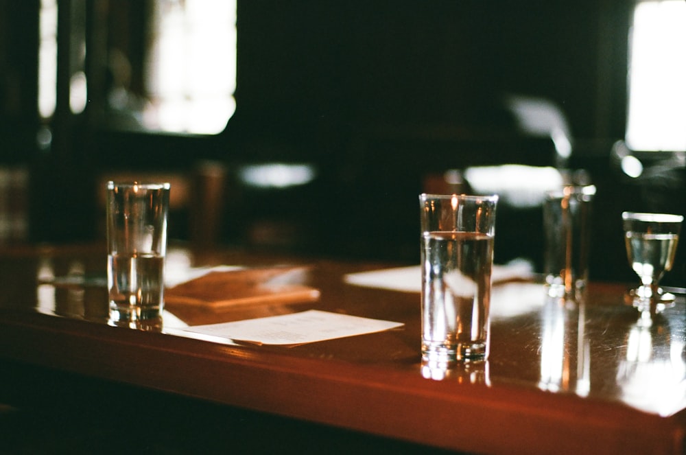 clear drinking glass on brown wooden table