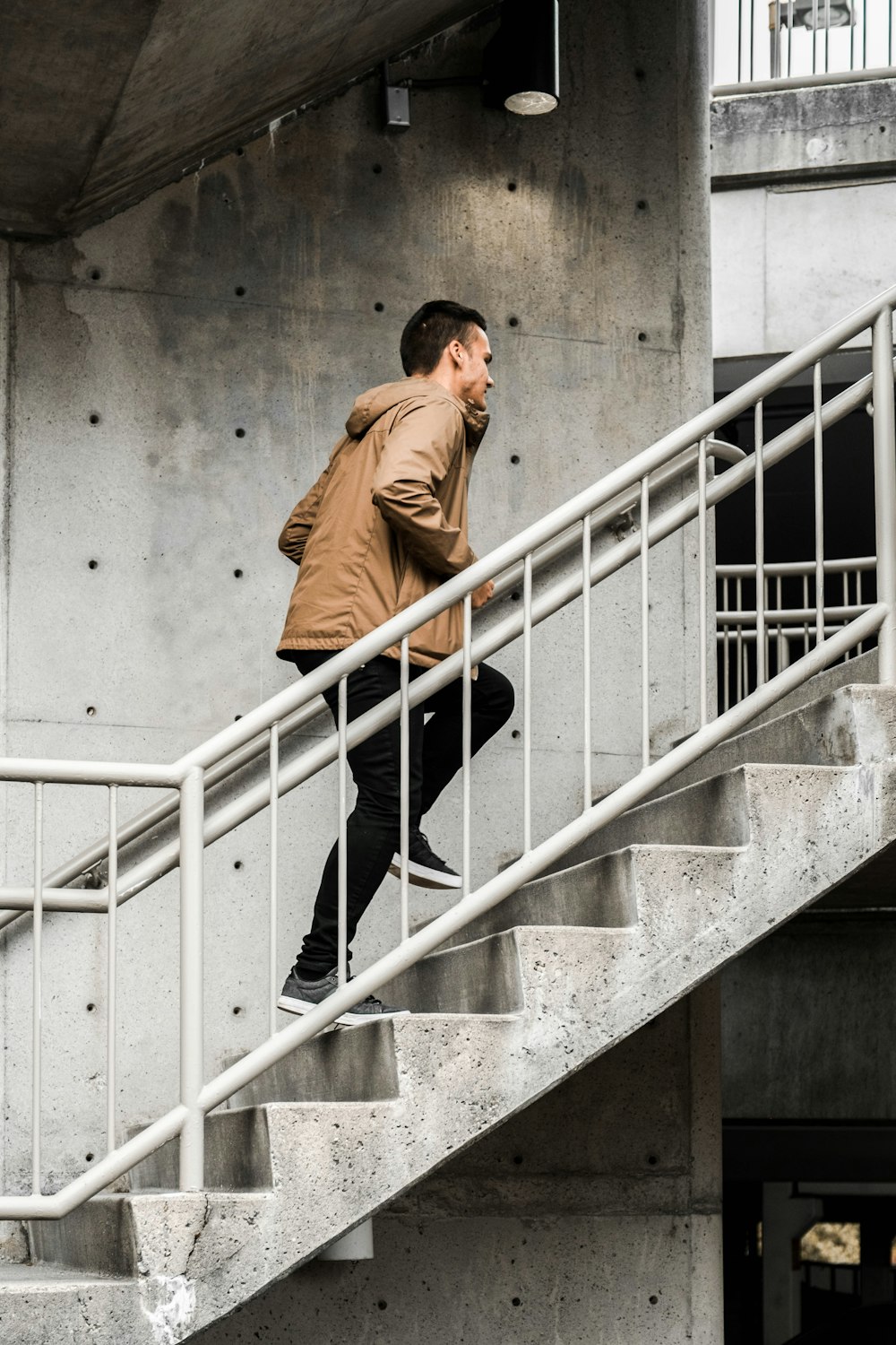 man in brown coat walking down the stairs