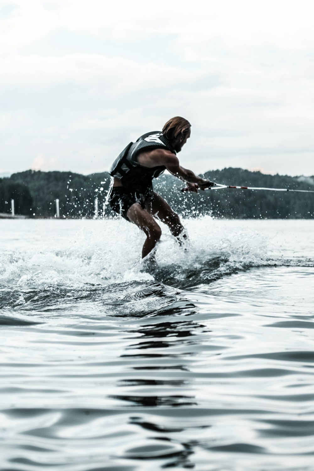 Hombre en pantalones cortos negros corriendo sobre el agua durante el día