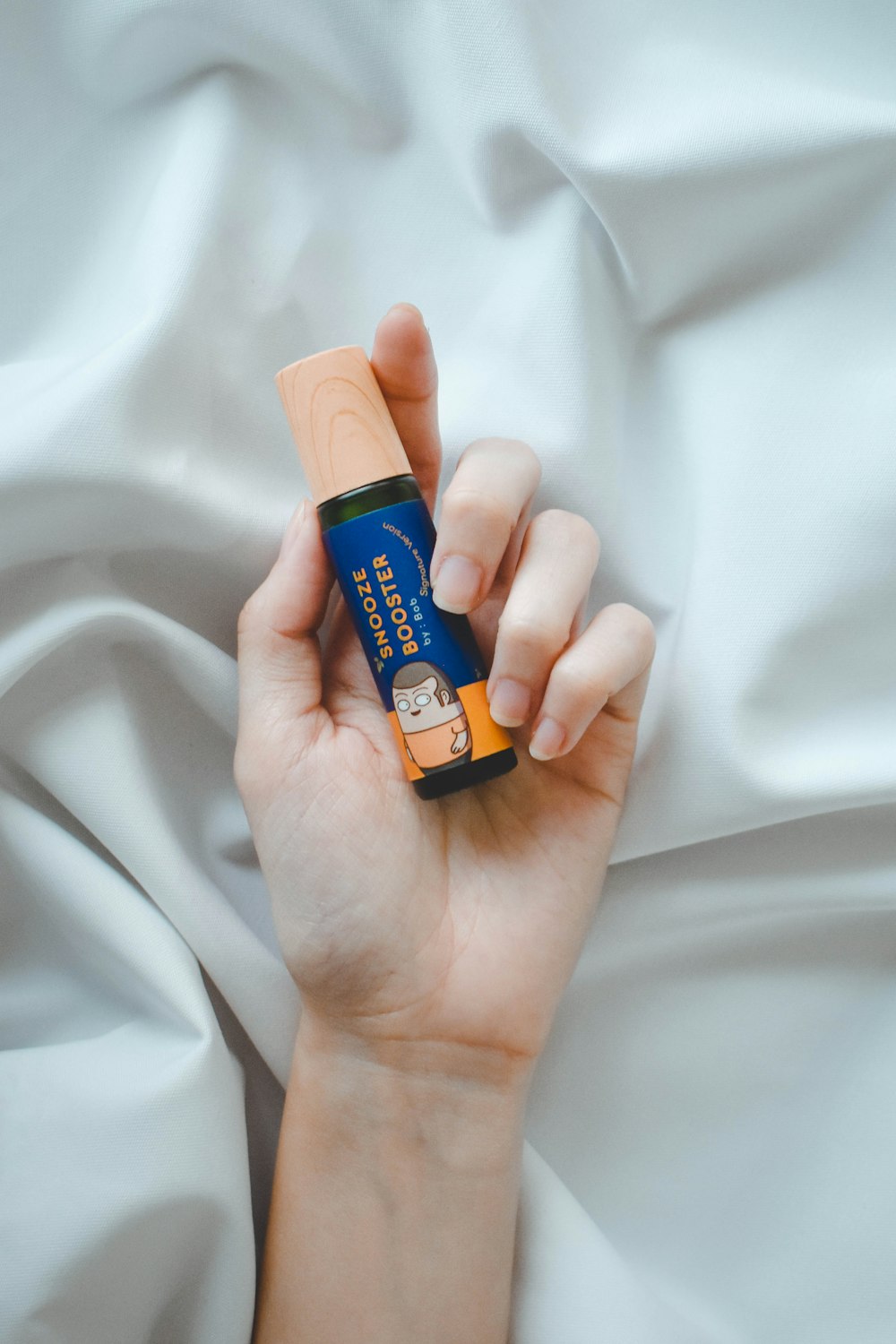 person holding orange and blue plastic bottle