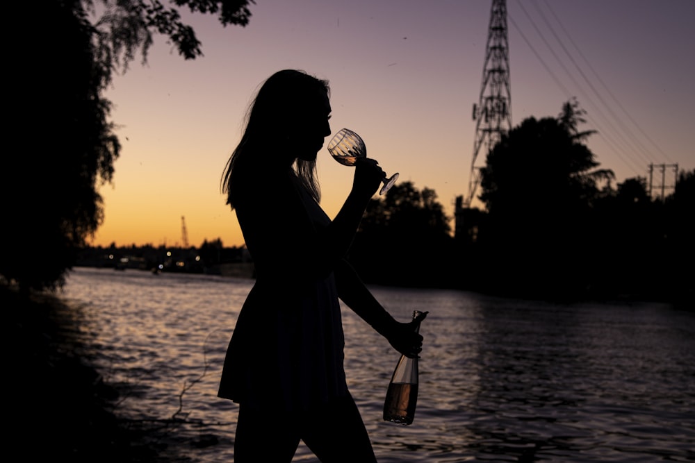 silhouette of woman drinking from bottle