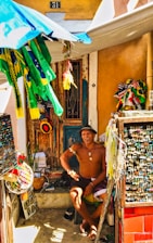 A small Latin American entrepreneur happily managing inventory on a laptop at a market stall.