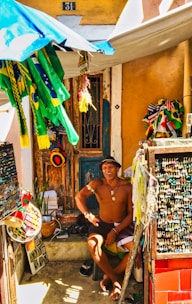 A small Latin American entrepreneur happily managing inventory on a laptop at a market stall.
