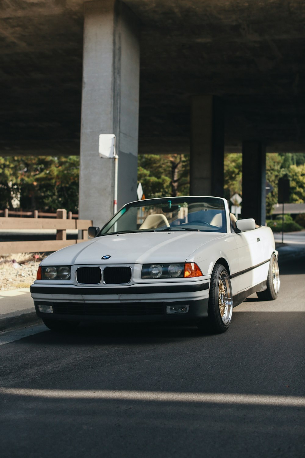 white bmw coupe parked near white concrete building during daytime